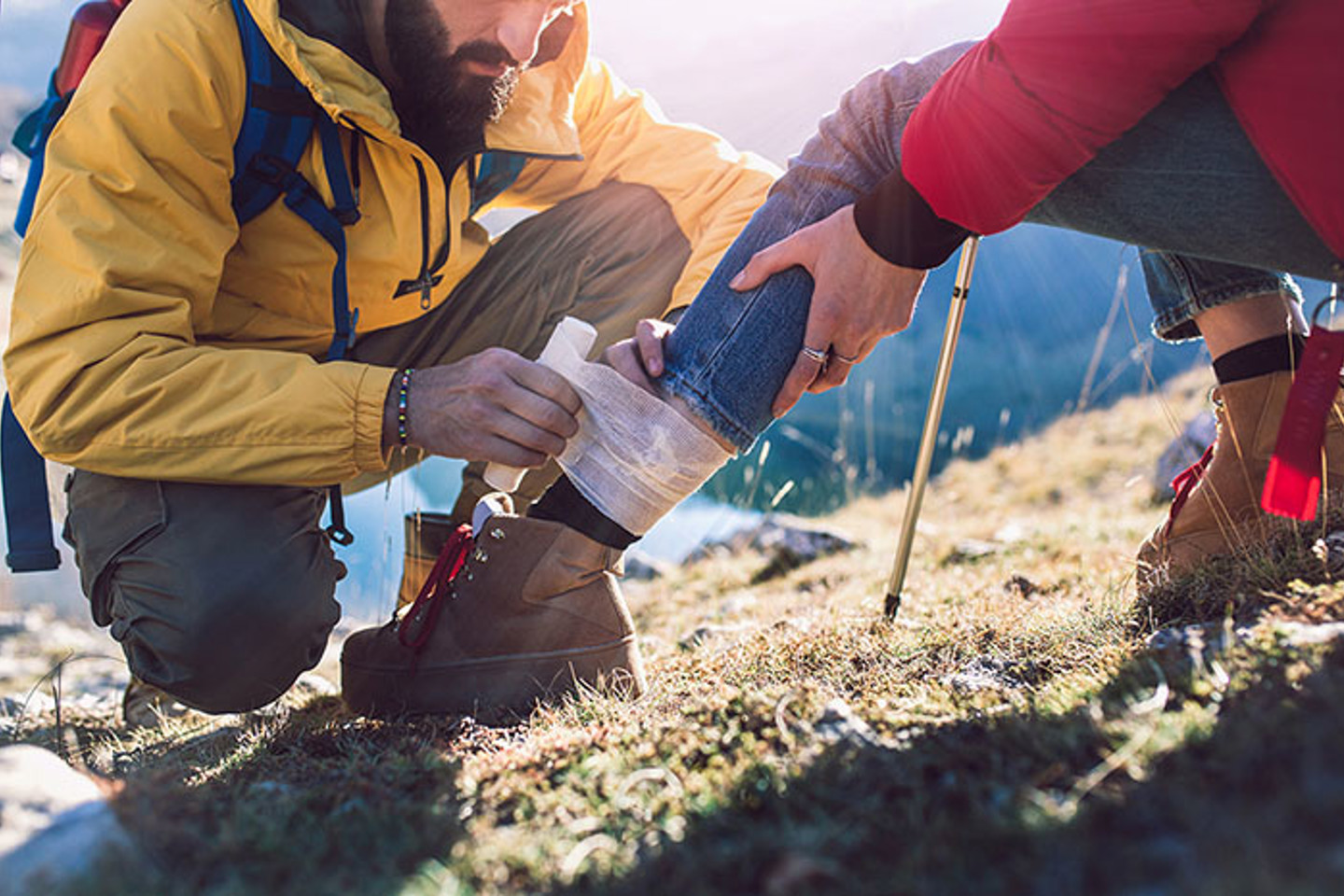 Person bandaging leg outdoors